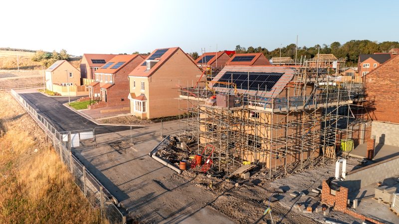 A large new build development seen from the air, roofs fitted with solar