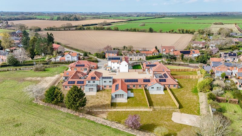 Aerial view of Lower Farm Mews, a nine home conversion in Tittleshall, Norfolk, with solar panels across the roofs