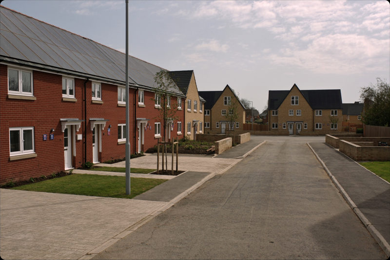 A new build street of houses with one terrace roof fully laid with solar panels