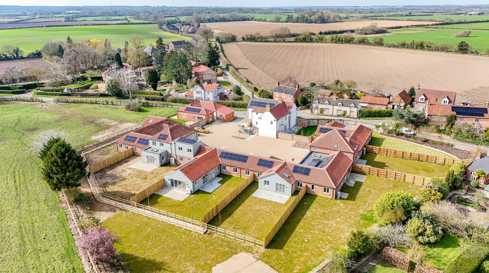 Lower Farm Mews seen from the air with the Norfolk village and fields behind